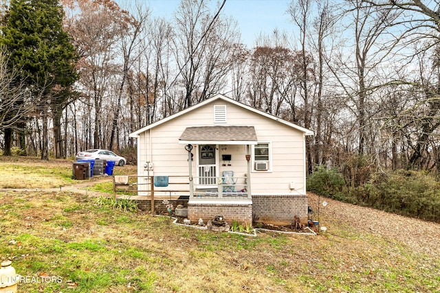 bungalow-style house with a porch and a front lawn