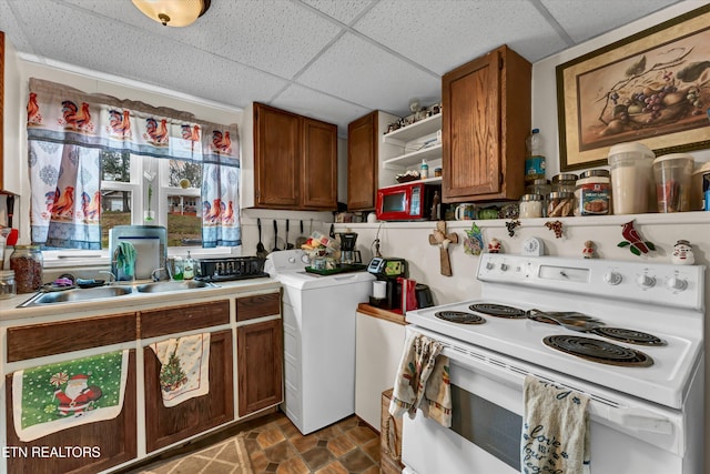 kitchen featuring washer / clothes dryer, white electric stove, a drop ceiling, and sink