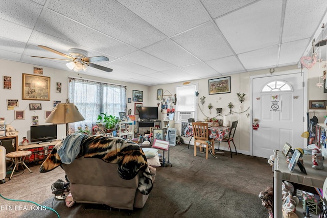 living room featuring a paneled ceiling, dark carpet, and ceiling fan