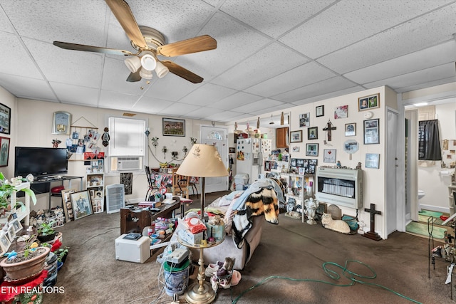 living room featuring a paneled ceiling, ceiling fan, carpet flooring, and heating unit