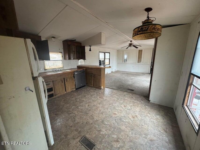 kitchen with plenty of natural light, white refrigerator, and kitchen peninsula