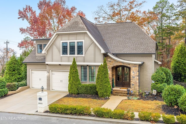 english style home featuring a garage and french doors