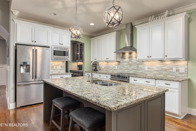 kitchen with a kitchen island with sink, dark wood-type flooring, white cabinets, wall chimney exhaust hood, and stainless steel appliances