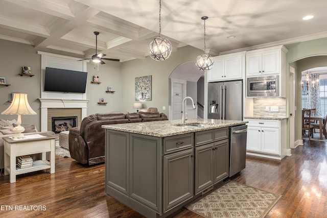 kitchen with appliances with stainless steel finishes, dark hardwood / wood-style floors, white cabinetry, and sink