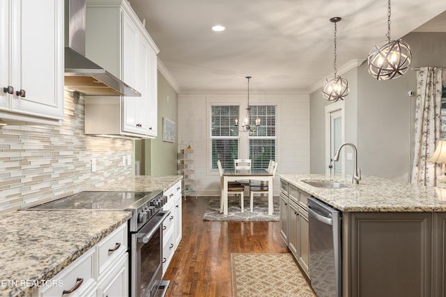 kitchen featuring sink, wall chimney exhaust hood, dark wood-type flooring, white cabinets, and appliances with stainless steel finishes