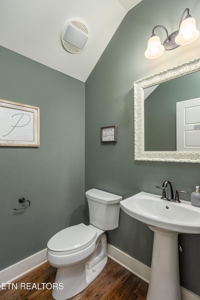 bathroom with toilet, lofted ceiling, and hardwood / wood-style flooring