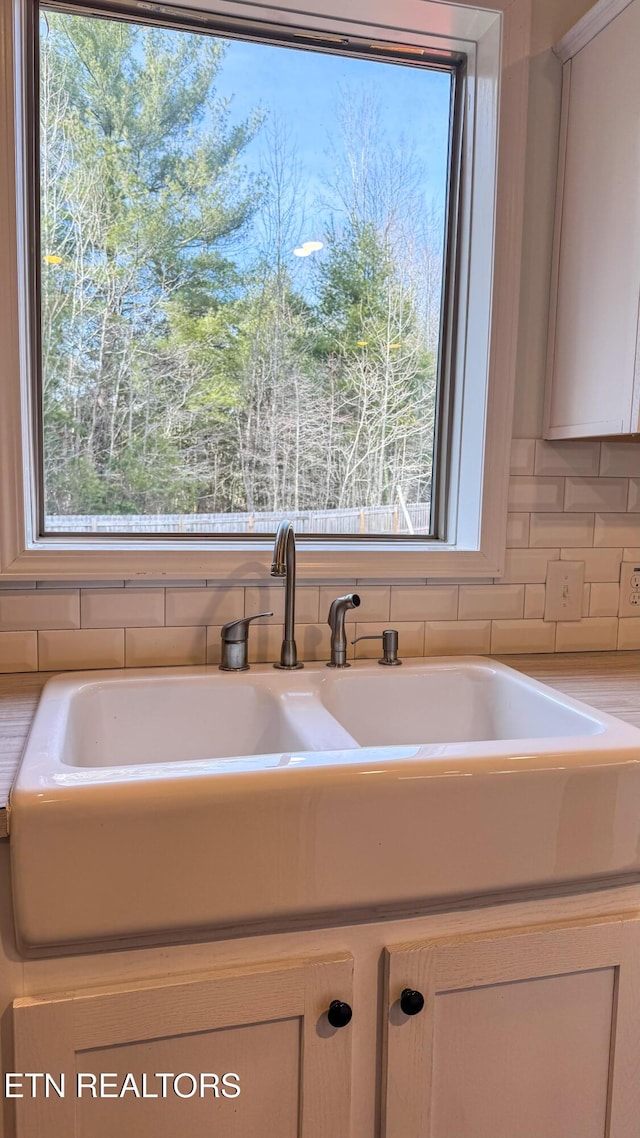 details with sink, backsplash, and white cabinets