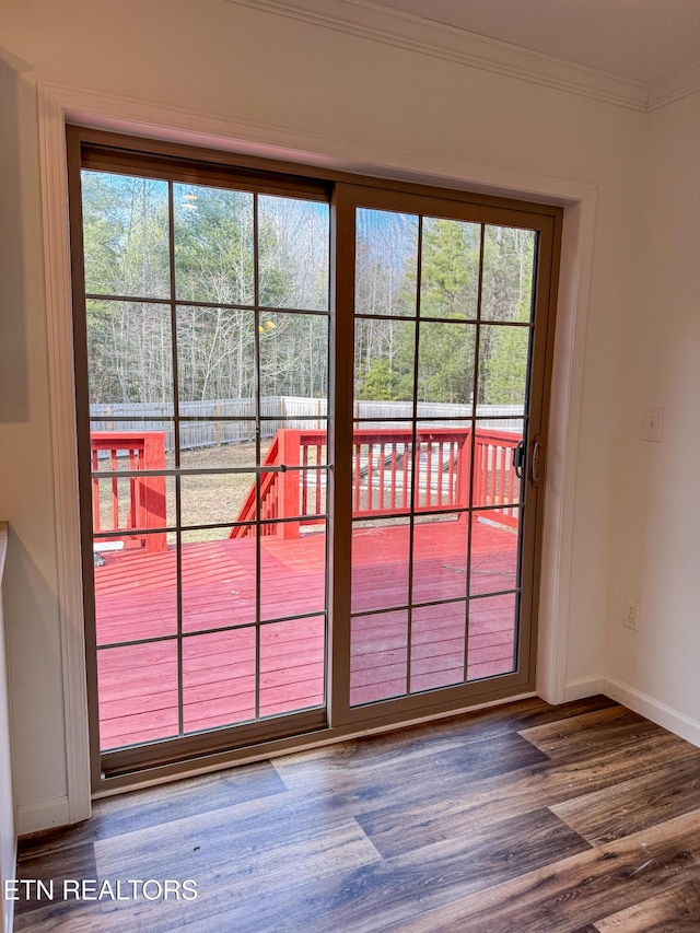 doorway to outside with a wealth of natural light, wood-type flooring, and ornamental molding