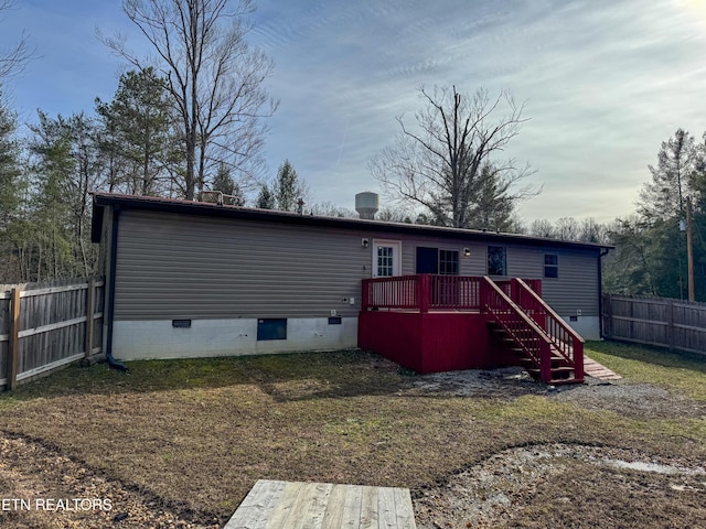 rear view of house featuring a deck and a lawn