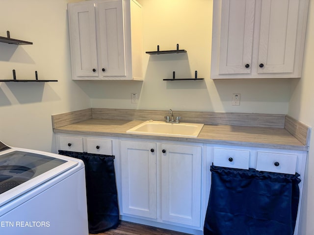 kitchen featuring sink, white cabinetry, and washer / dryer