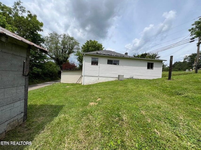 rear view of property with cooling unit and a lawn