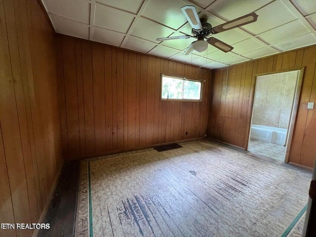 unfurnished room with light hardwood / wood-style floors, ceiling fan, and wood walls