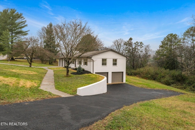 view of front of house with a garage and a front lawn