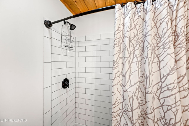 bathroom with curtained shower and wooden ceiling