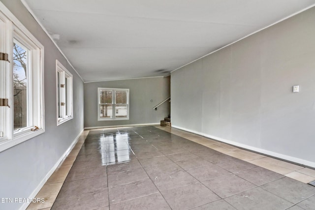 tiled empty room with vaulted ceiling