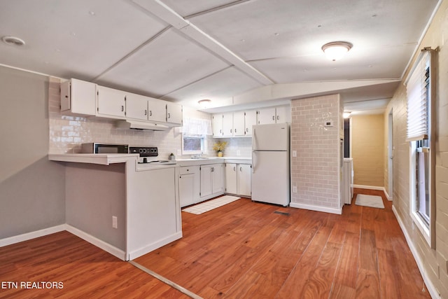 kitchen featuring range with electric cooktop, light hardwood / wood-style floors, vaulted ceiling, white fridge, and white cabinetry