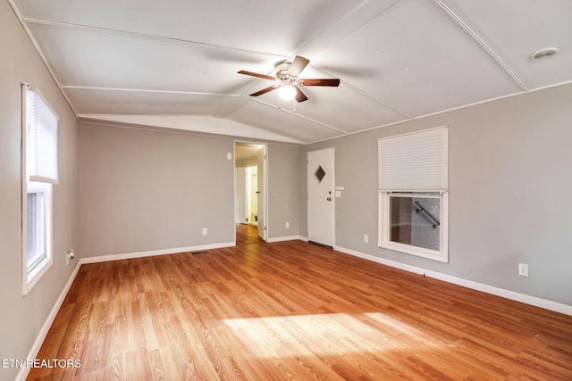 spare room with ceiling fan, a healthy amount of sunlight, vaulted ceiling, and hardwood / wood-style flooring