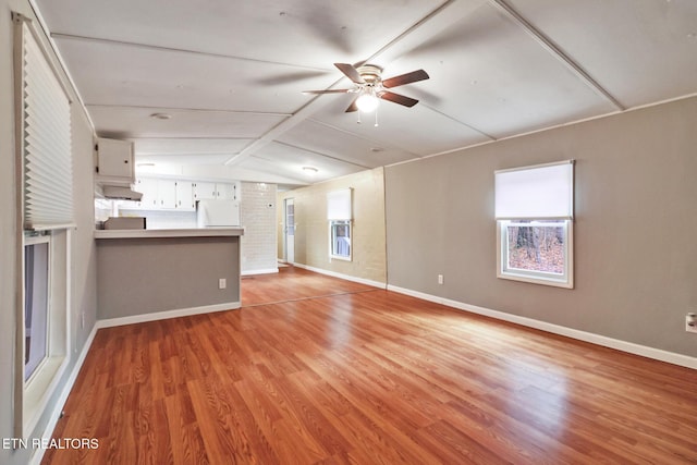 unfurnished living room with plenty of natural light, light hardwood / wood-style floors, and vaulted ceiling