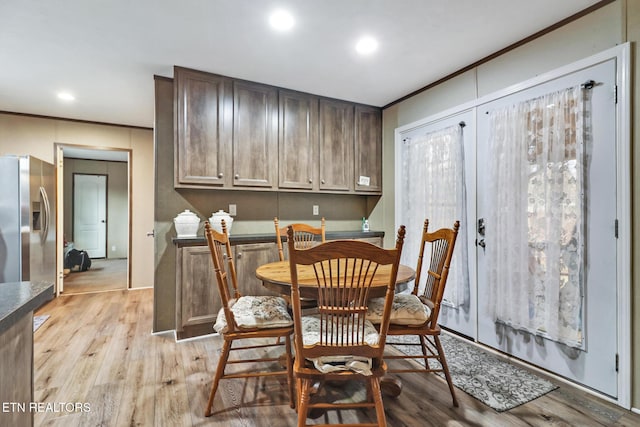 dining space featuring light hardwood / wood-style flooring and crown molding