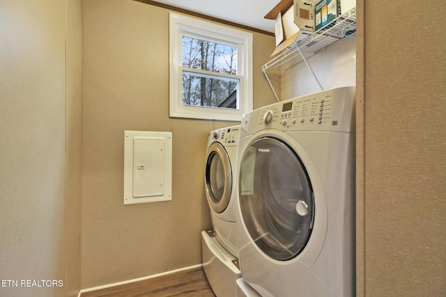 washroom featuring washer and dryer, electric panel, and hardwood / wood-style flooring