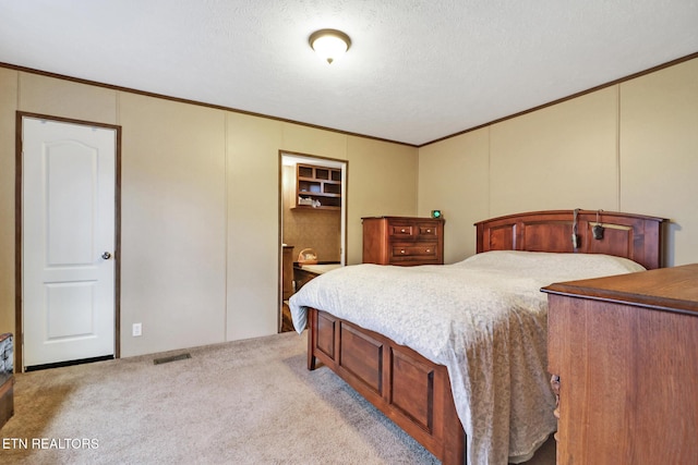 bedroom featuring light carpet, crown molding, and a textured ceiling