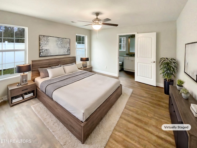 bedroom with connected bathroom, ceiling fan, and hardwood / wood-style flooring