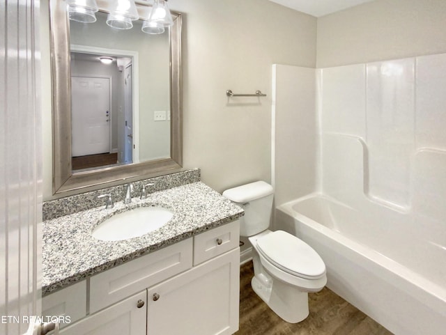 full bathroom with hardwood / wood-style floors, vanity, toilet, and shower / washtub combination