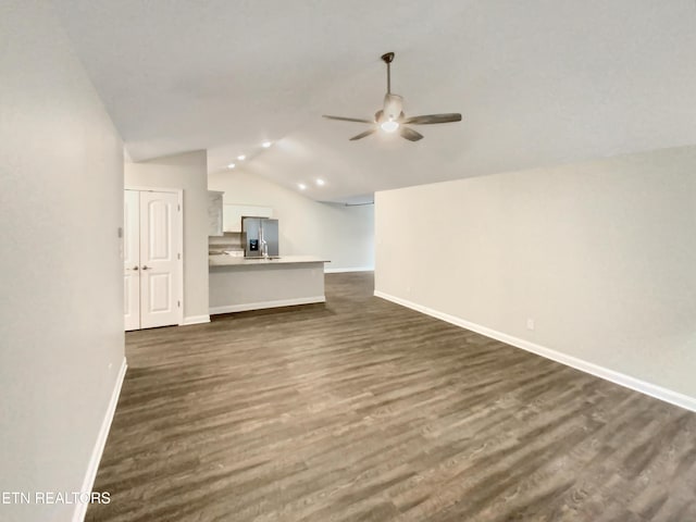 unfurnished living room featuring dark hardwood / wood-style floors, ceiling fan, and lofted ceiling