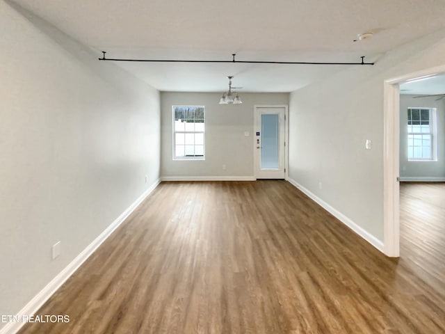 spare room featuring a chandelier and wood-type flooring