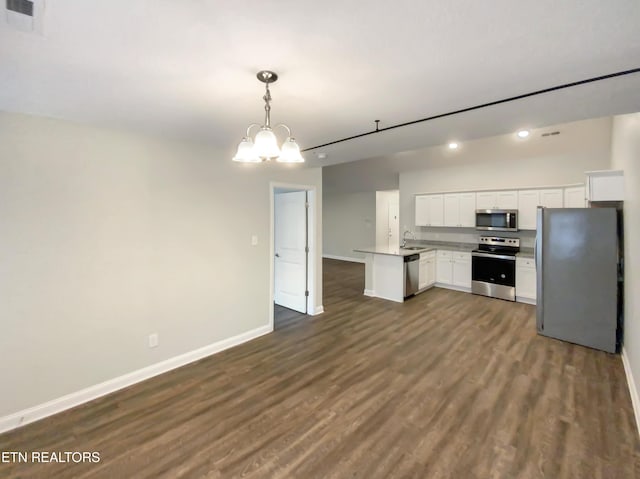 kitchen with white cabinets, appliances with stainless steel finishes, dark hardwood / wood-style floors, and hanging light fixtures