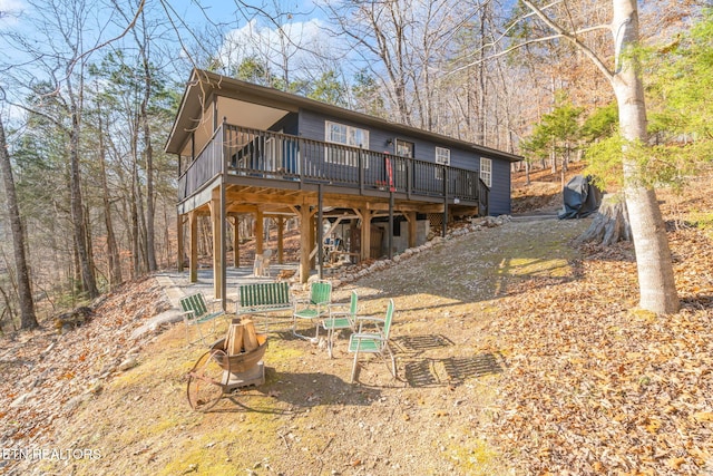 rear view of house with an outdoor fire pit and a wooden deck