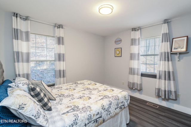 bedroom with dark wood-type flooring