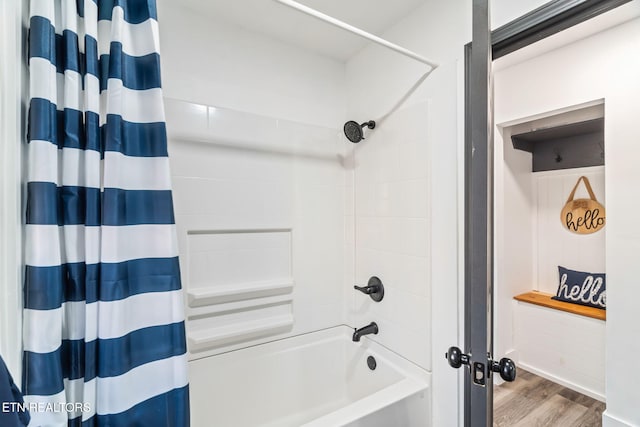 bathroom with hardwood / wood-style flooring and shower / tub combo