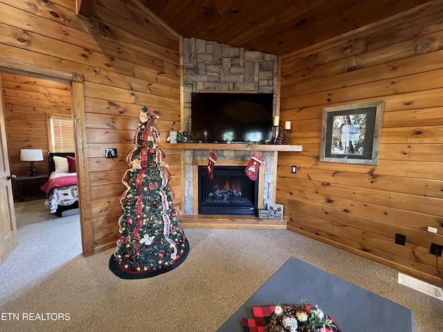 unfurnished living room featuring carpet flooring, wood walls, a fireplace, and lofted ceiling