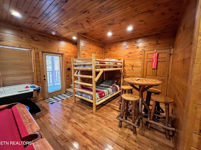 bedroom featuring wood walls, wood-type flooring, access to outside, and wooden ceiling