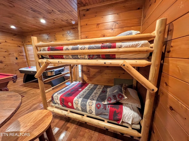 bedroom with hardwood / wood-style floors, billiards, wooden walls, and wood ceiling