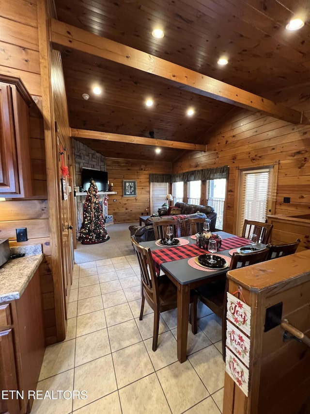 tiled dining area featuring lofted ceiling with beams, wood walls, and wood ceiling