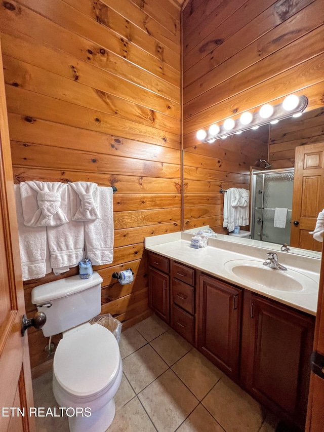 bathroom with wooden walls, tile patterned flooring, vanity, and toilet