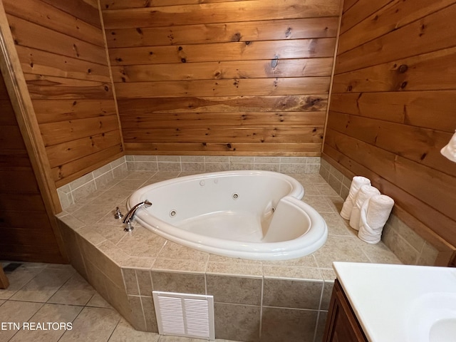 bathroom featuring tiled tub, wood walls, and tile patterned flooring