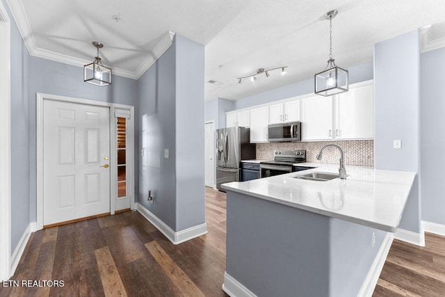 kitchen featuring white cabinetry, sink, hanging light fixtures, stainless steel appliances, and kitchen peninsula