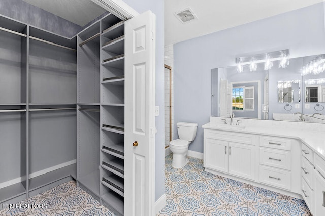 walk in closet with light tile patterned floors and sink