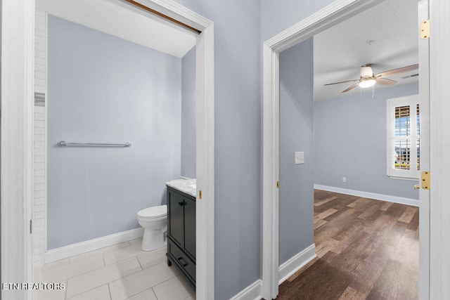 bathroom featuring vanity, hardwood / wood-style flooring, toilet, and ceiling fan