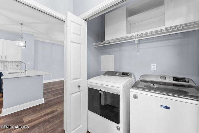 washroom featuring crown molding, washer and dryer, sink, and dark wood-type flooring