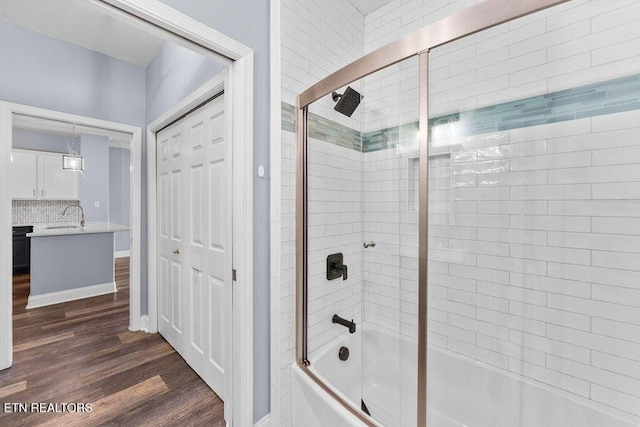 bathroom with vanity, enclosed tub / shower combo, and hardwood / wood-style flooring