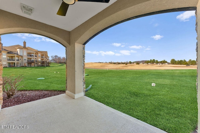 view of yard featuring ceiling fan and a patio