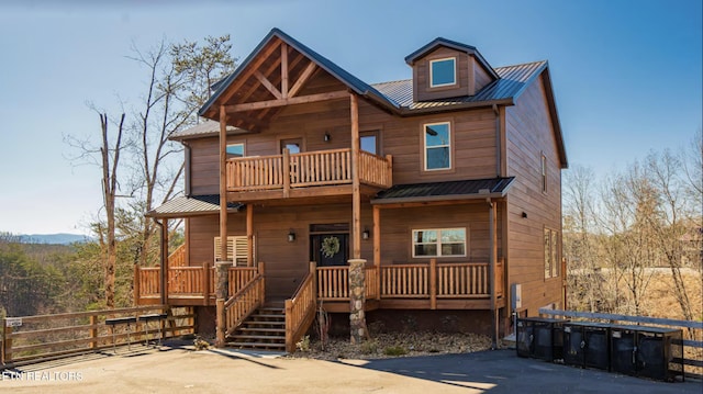 cabin with covered porch and a balcony