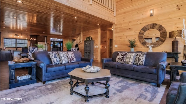 living room featuring a chandelier, wooden ceiling, and wood walls