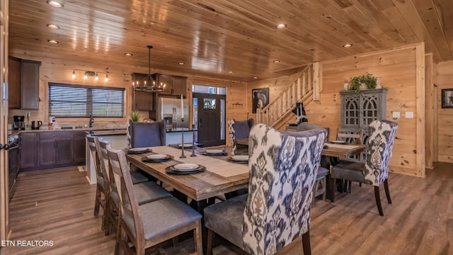 dining room featuring hardwood / wood-style floors, wooden ceiling, wooden walls, and a notable chandelier