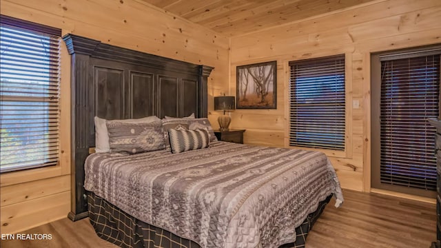 bedroom with hardwood / wood-style flooring, wooden walls, and wood ceiling