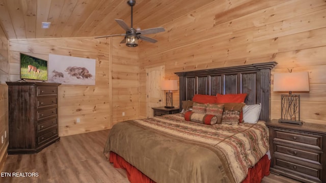 bedroom with wooden walls, hardwood / wood-style floors, wooden ceiling, and lofted ceiling